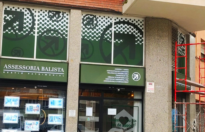 adhesivos colocados en la parte exterior de una empresa para evitar la entrada del sol y ser mucho mas llamativos a vision del cliente gran impresión inmobiliaria balista barcelona